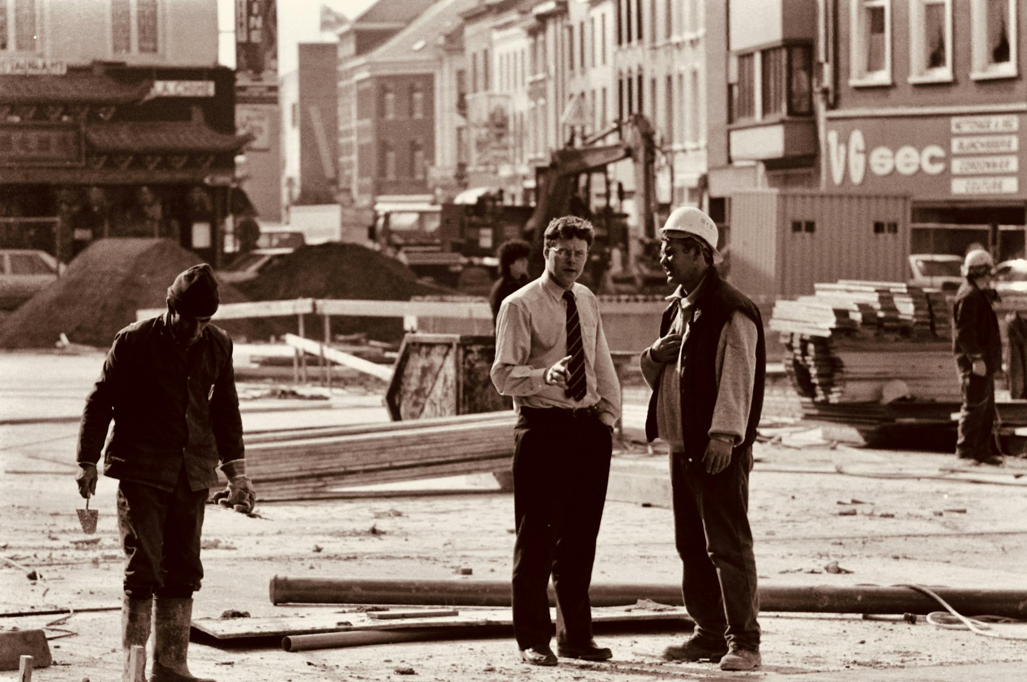 Sepia-toned street view of construction workers in Charleroi, Belgium.